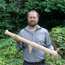 Dr. Bastian Asmus mit dem von ihm gefertigten Holzmodell des Laufs der Hakenbüchse