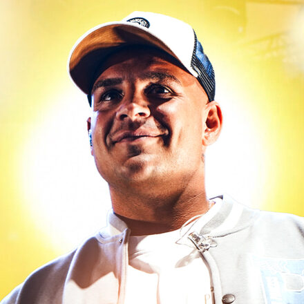 Pietro Lombardi mit einer Baseballkappe auf dem Kopf vor einem gelben Hintergrund.