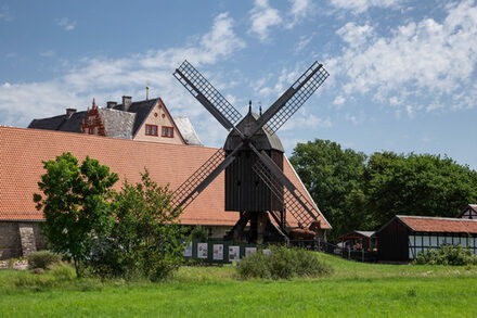 Die Osterlinder Bockwindmühle vor der Kulisse der Gebäude des Städtischen Museums Schloss Salder.