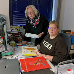 Jessica Färber-Stecher (sitzend am Schreibtisch) und Barbara Henning vom Veranstaltungsteam der Stadtbibliothek bei der Vorbereitung der Lesungen.