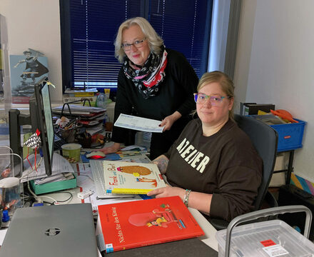 Jessica Färber-Stecher (sitzend am Schreibtisch) und Barbara Henning vom Veranstaltungsteam der Stadtbibliothek bei der Vorbereitung der Lesungen.