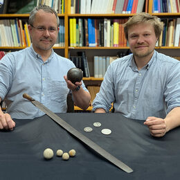Museumsleiter Arne Homann (links) und Bezirksarchäologe Tobias Uhlig (rechts) präsentieren Funde aus der Zeit des Dreißigjährigen Krieges
