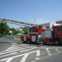 Ein Leiterwagen der Feuerwehr. Im Korb des Auslegers steht ein Feuerwehrmann.