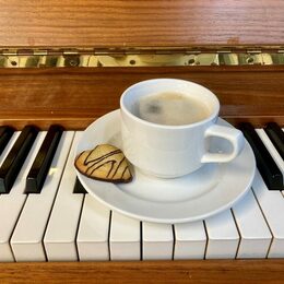 Eine Tasse Kaffee steht auf einem Klavier