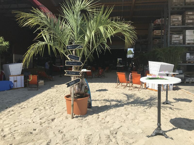 Palme und Cocktailtische im Sand